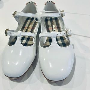 This double-strap mary-jane flat in optic-white leather. Adjustable straps